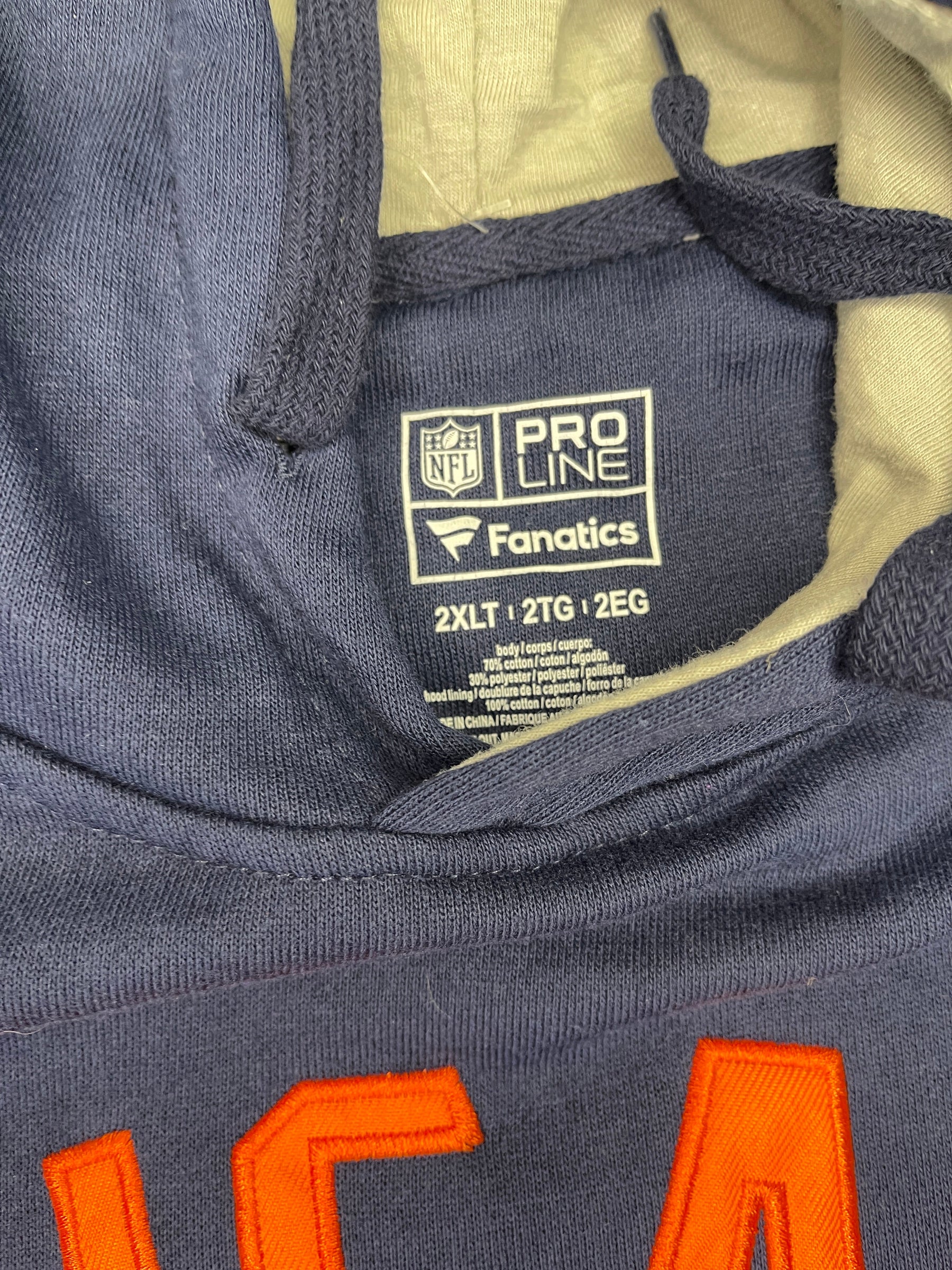 Navy jacket with orange lettering and a visible brand label